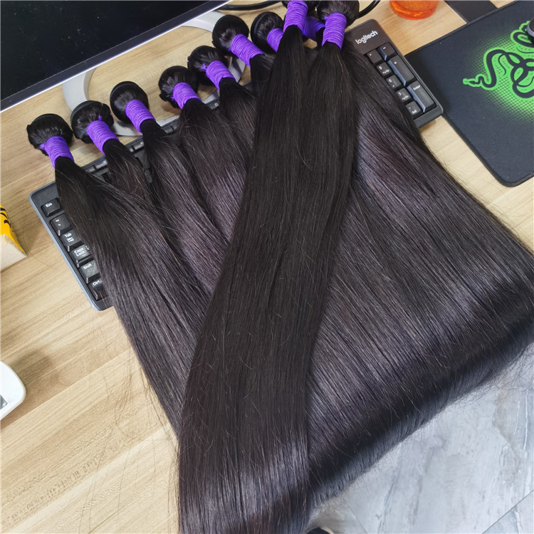 Raw Virgin Human Hair Wholesale silky straight bundles with purple bands displayed on a desk, representing Helene Hair factory-direct inventory.